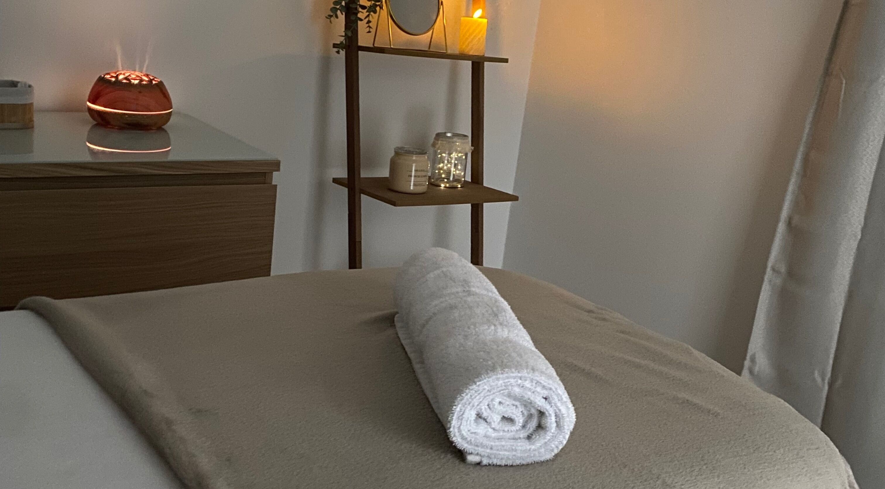 Salle de massage relaxante au Le Boudoir De Camille, Troyes, Grand Est, FR avec serviette roulée et bougies.