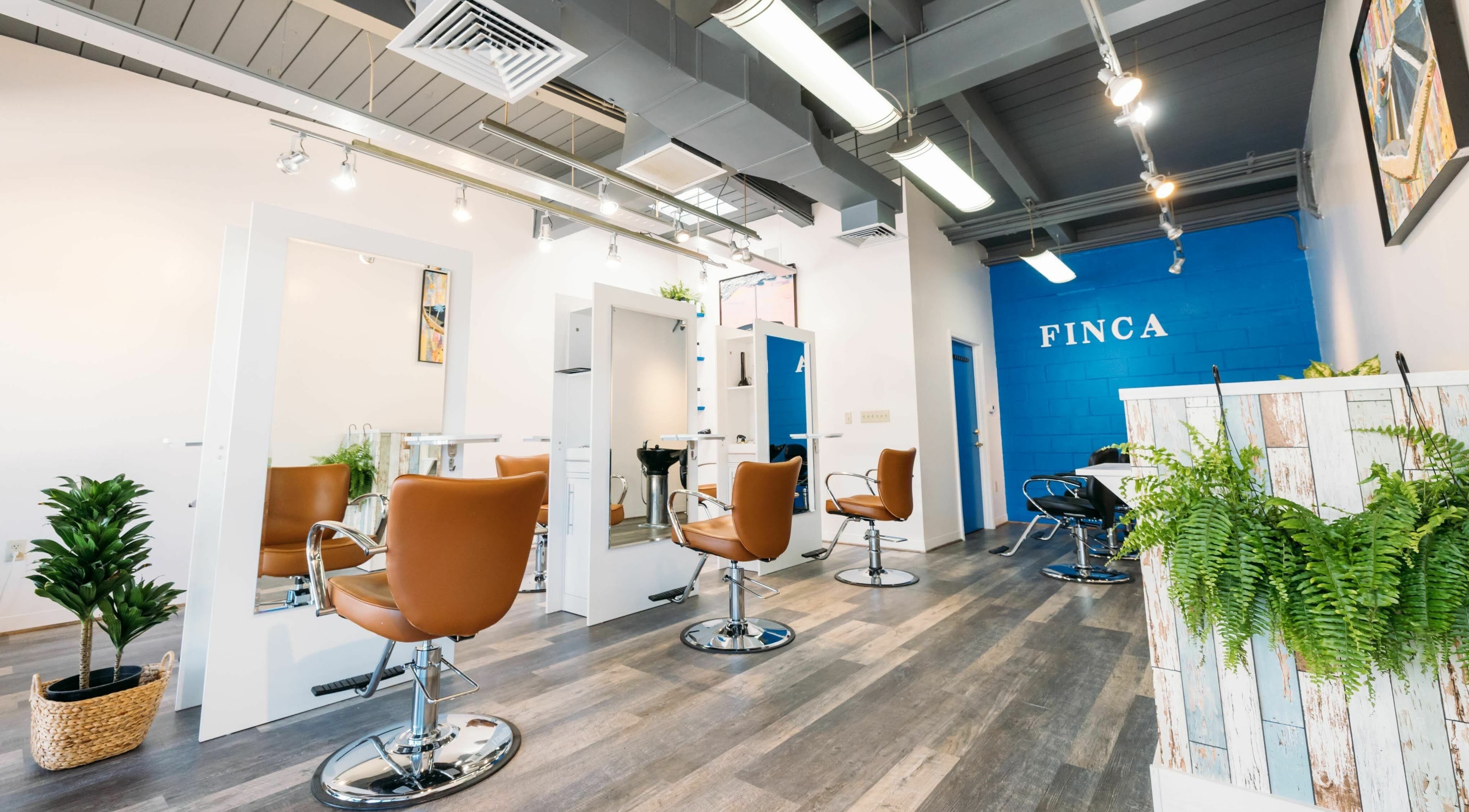Modern interior of Finca Beauty Salon - Aina Haina in Honolulu, Hawaii, US with stylish chairs and plants.