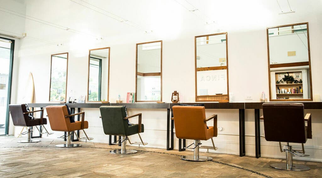 Modern salon chairs and mirrors at Finca Beauty Salon, Honolulu, Hawaii, US, showcasing a chic interior.