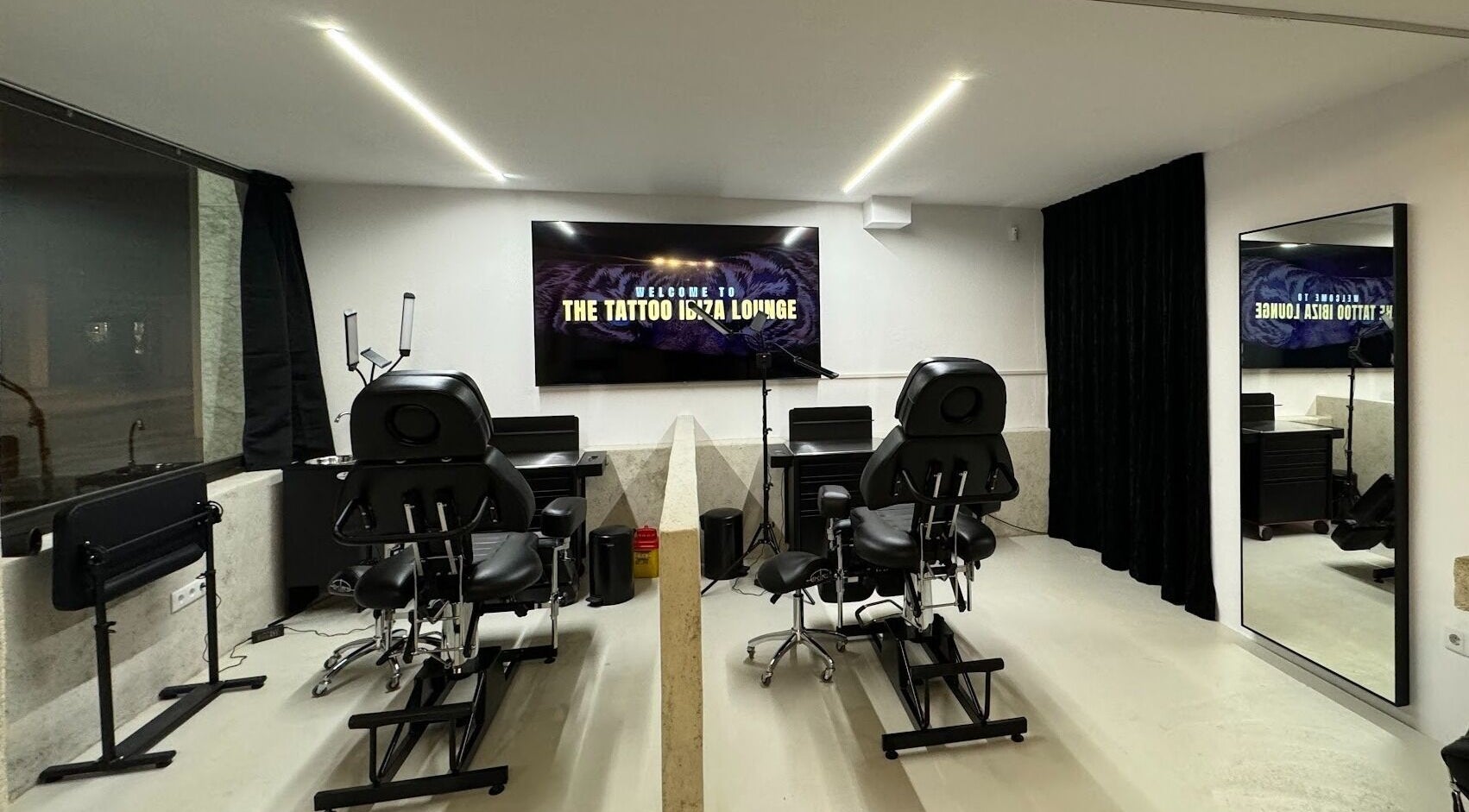 Modern tattoo studio at Tattoo Ibiza Lounge, Eivissa, Illes Balears, ES, featuring sleek chairs and equipment.