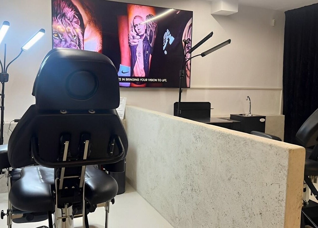 Modern tattoo station at Tattoo Ibiza Lounge, Eivissa, Illes Balears, ES, showcasing sleek chairs and vibrant artwork.