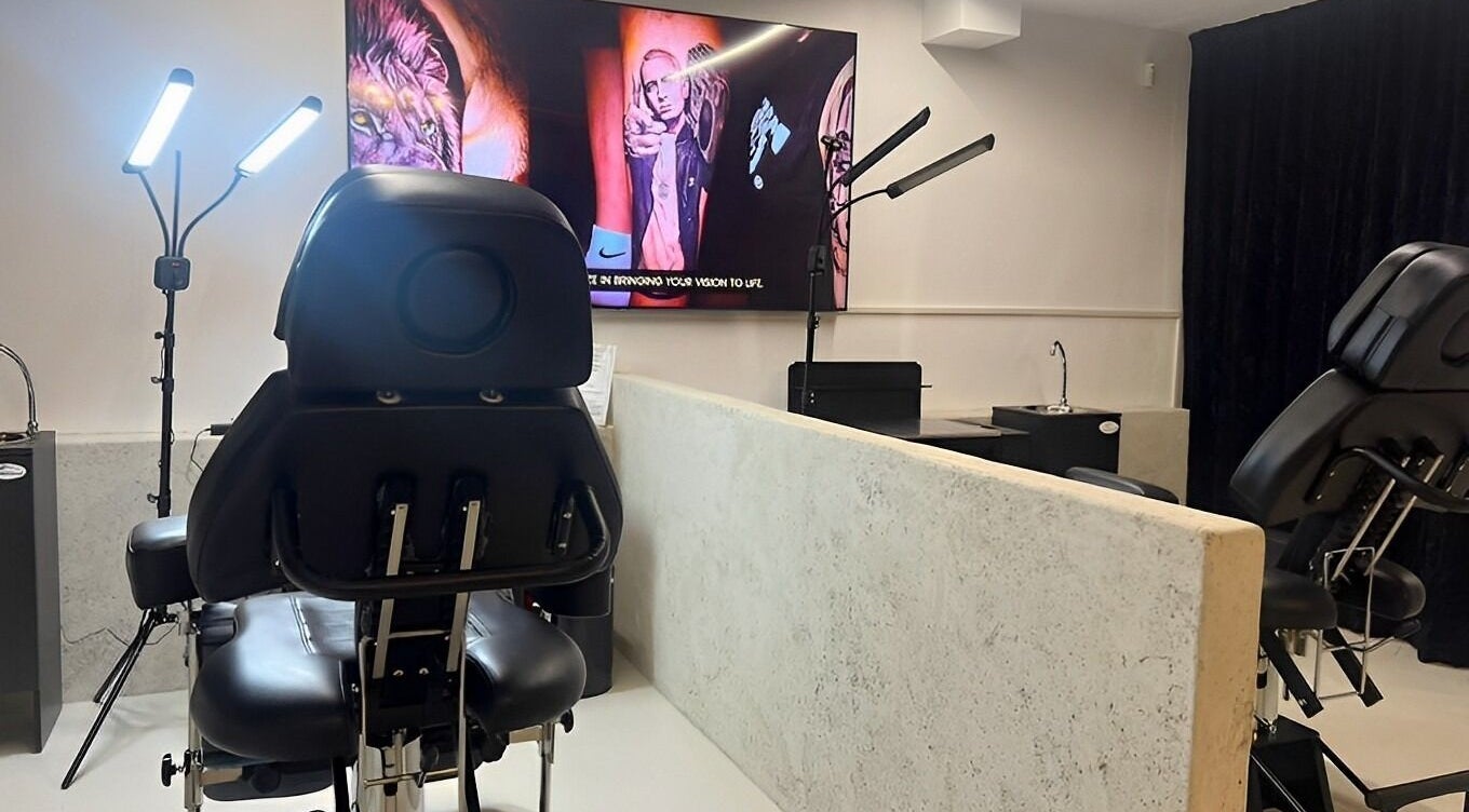 Modern tattoo station at Tattoo Ibiza Lounge, Eivissa, Illes Balears, ES, showcasing sleek chairs and vibrant artwork.