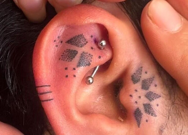 Close-up of stylish ear tattoo and piercing at Tattoo Ibiza Lounge, Eivissa, Illes Balears, ES.