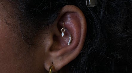 Elegant ear piercings at The Needle Room, London, England, GB, featuring gold and diamond jewelry.