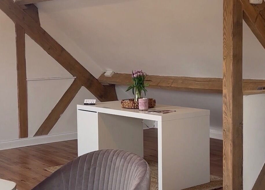 Stylish loft space at JL’s Hideaway Beauty & Aesthetics, Bewdley, England, GB featuring a modern desk and beams.