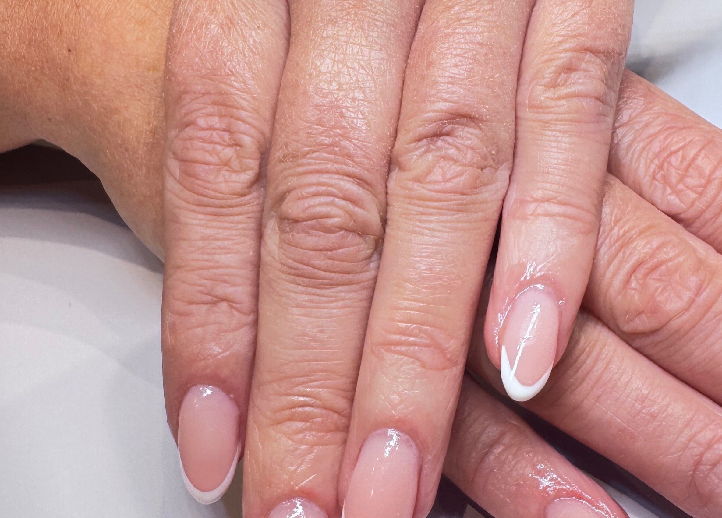 Elegant French manicure at The Wellness Hub, Blackburn, England, GB. Perfectly polished nails on display.