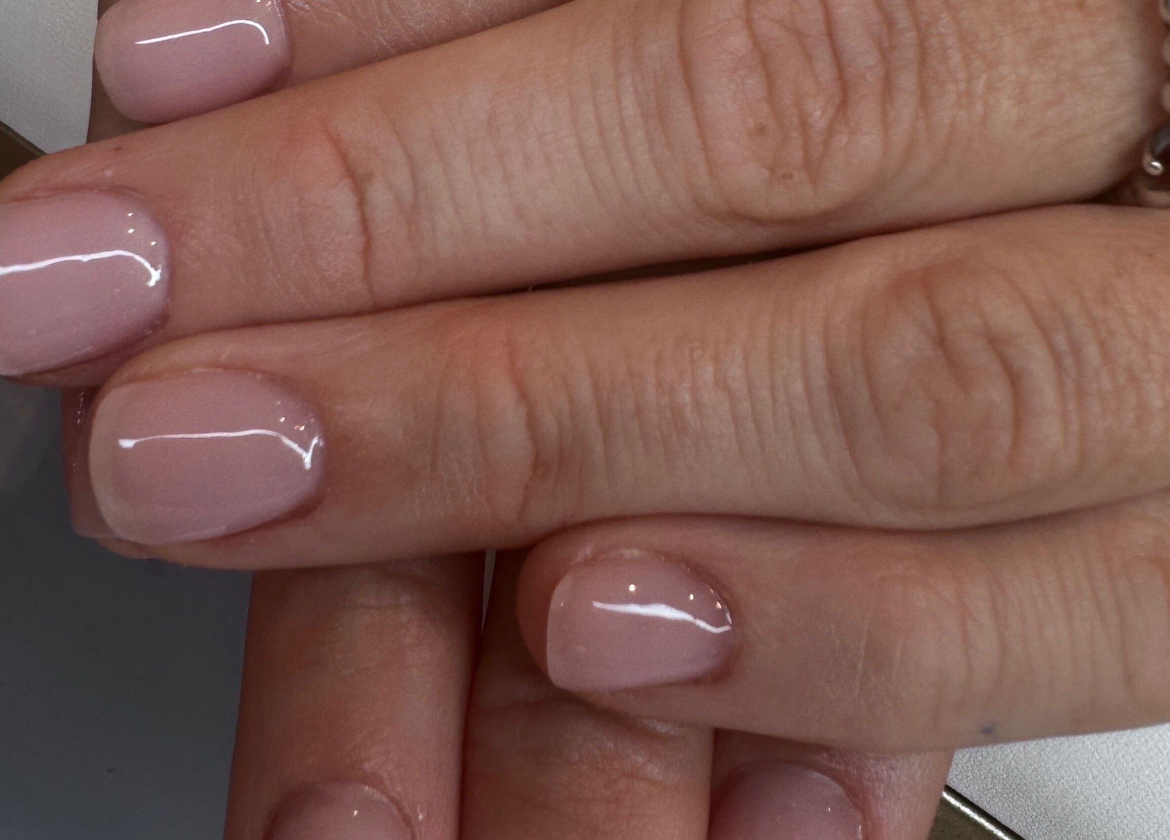 Elegant manicure at The Wellness Hub, Blackburn, England, GB. Shiny, natural pink nails on display.