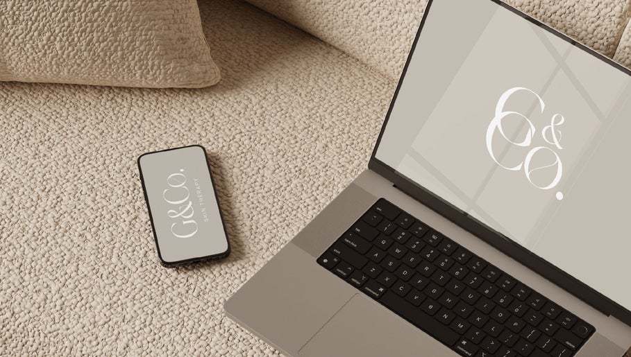 Laptop and phone with G&Co. logo at cozy venue in Liverpool, England, GB.