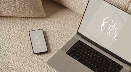 Laptop and phone with G&Co. logo at cozy venue in Liverpool, England, GB.