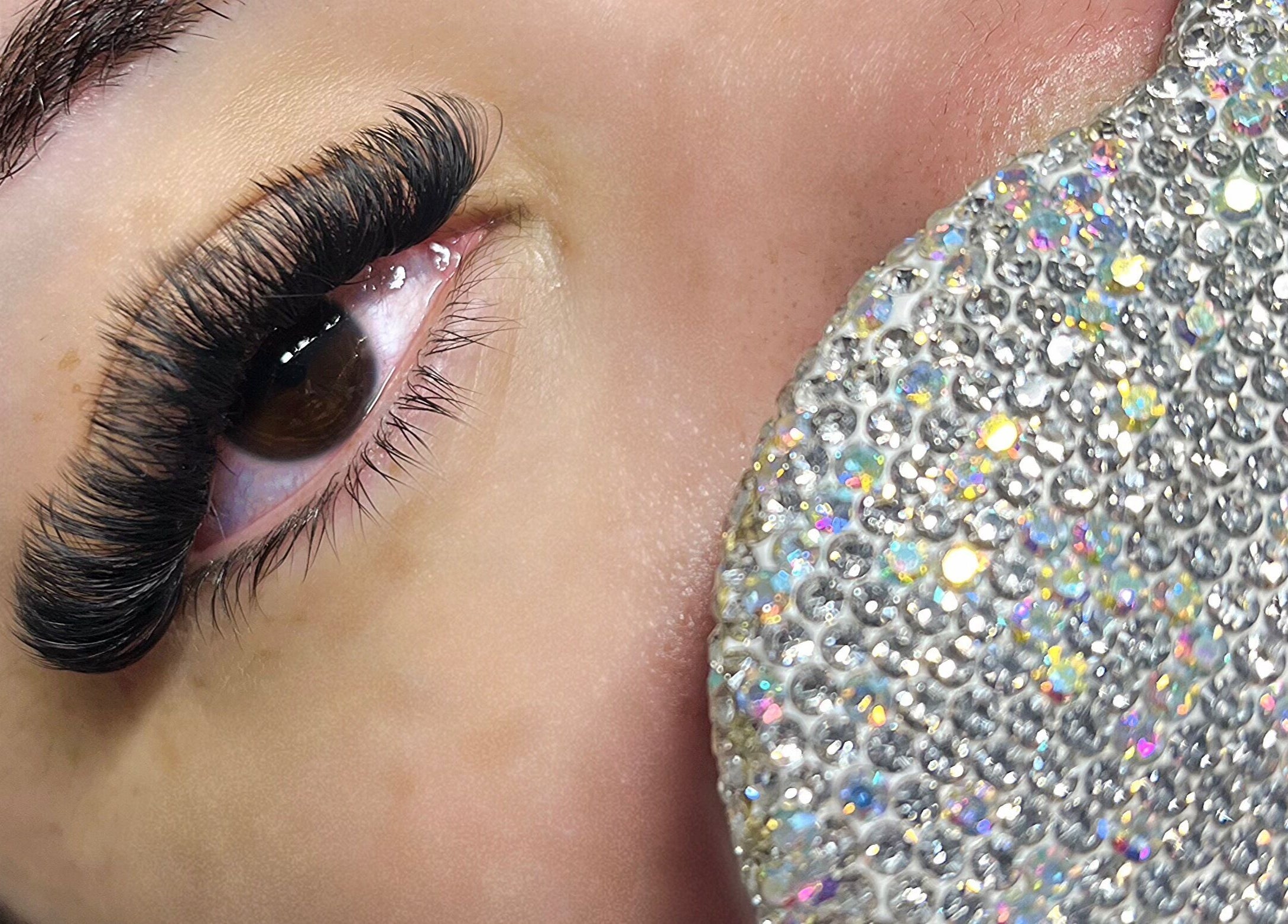 Cils volumineux et élégants à EVACILS, Montréal, Québec, CA, avec étincelles en arrière-plan.