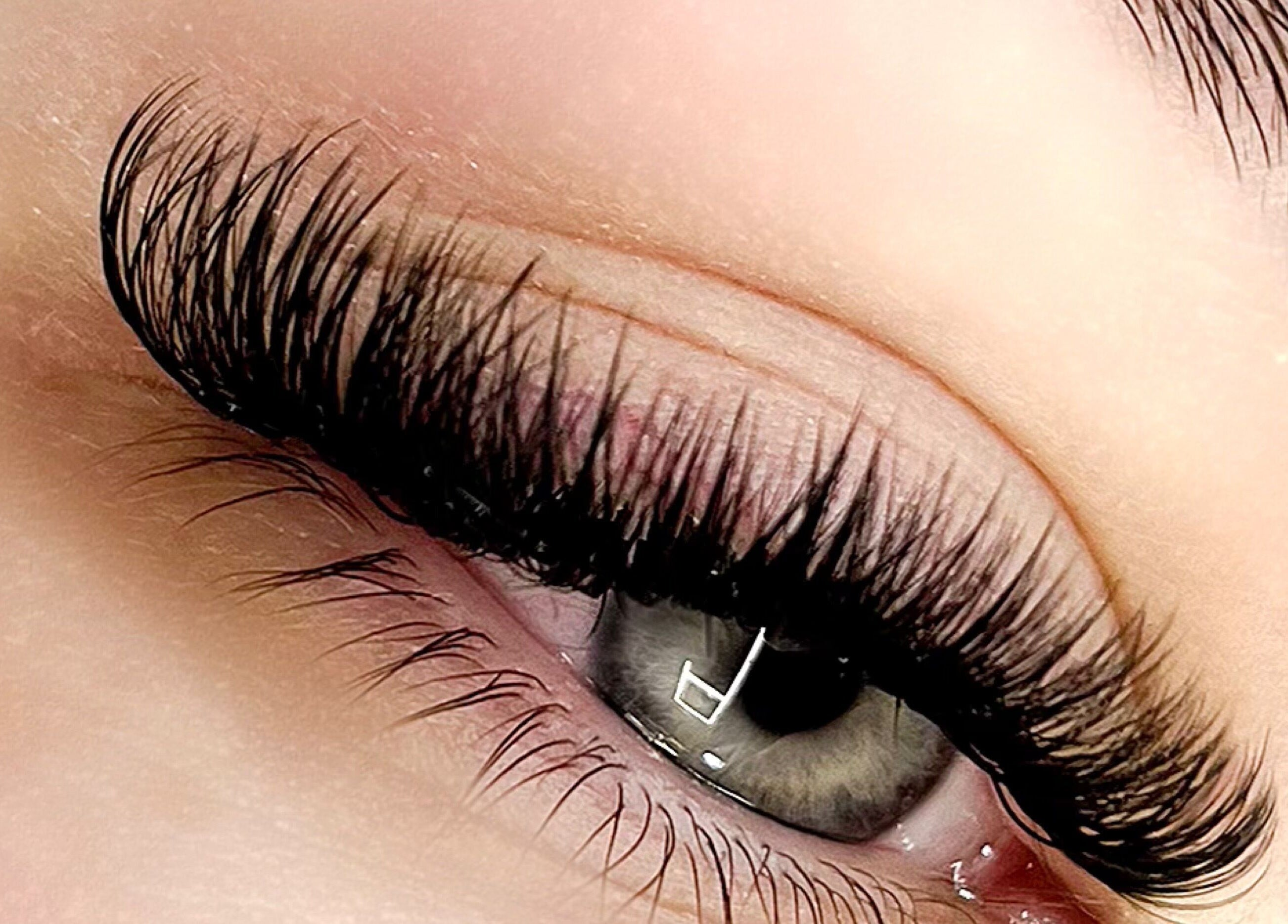 Extension de cils magnifiquement réalisée chez EVACILS à Montréal, Québec, CA, mettant en valeur un regard intense.