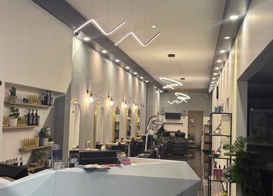 Interior moderno do Enrich Beauty em Rockdale, New South Wales, AU, com espelhos dourados e iluminação elegante.