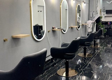 Interior sofisticado do Monalisa Hairdresser em Rockdale, New South Wales, AU com cadeiras modernas e espelhos iluminados.