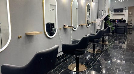 Interior sofisticado do Monalisa Hairdresser em Rockdale, New South Wales, AU com cadeiras modernas e espelhos iluminados.