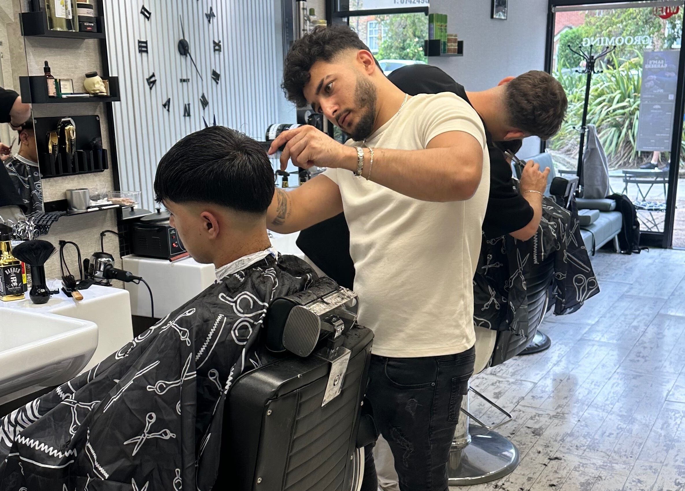 Barber styling client's hair at Sam’s Barbers London, London, England, GB.