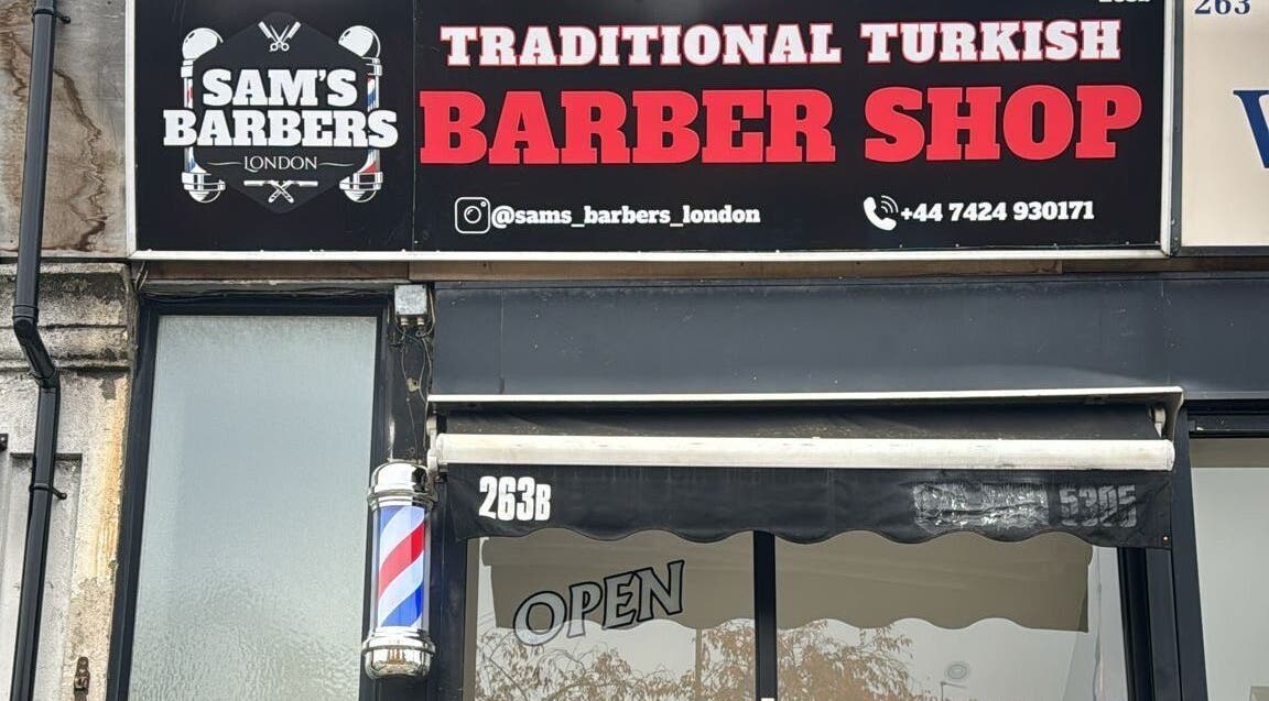 Exterior of Sam’s Barbers London located in London, England, GB, showcasing a traditional Turkish barber shop sign.