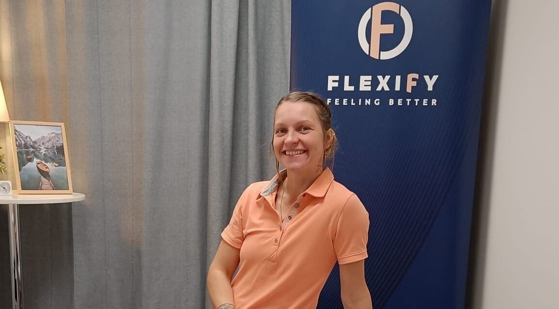 Hymyilevä henkilö Flexify, Kauppakeskus Veska -kyltin edessä, Pirkanmaa, Pirkanmaa, FI.