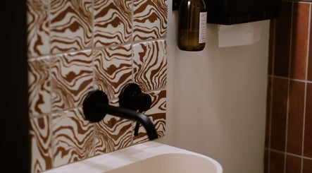 Stylish faucet with artistic tiles at Cleo Rogers Skincare - SHY Studios, Lewes, England, GB.