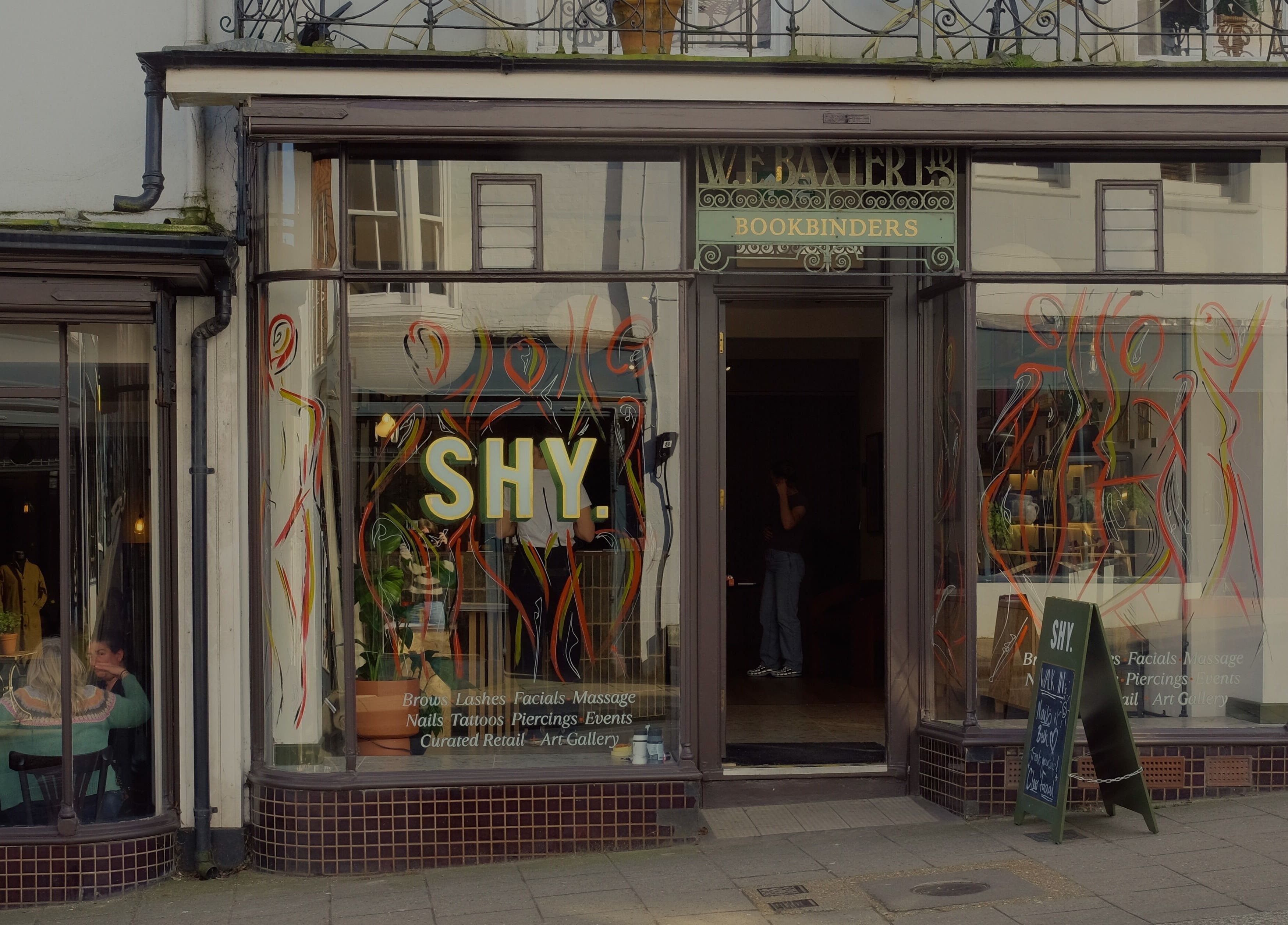 Front view of Cleo Rogers Skincare - SHY Studios in Lewes, England, showcasing vibrant window designs.