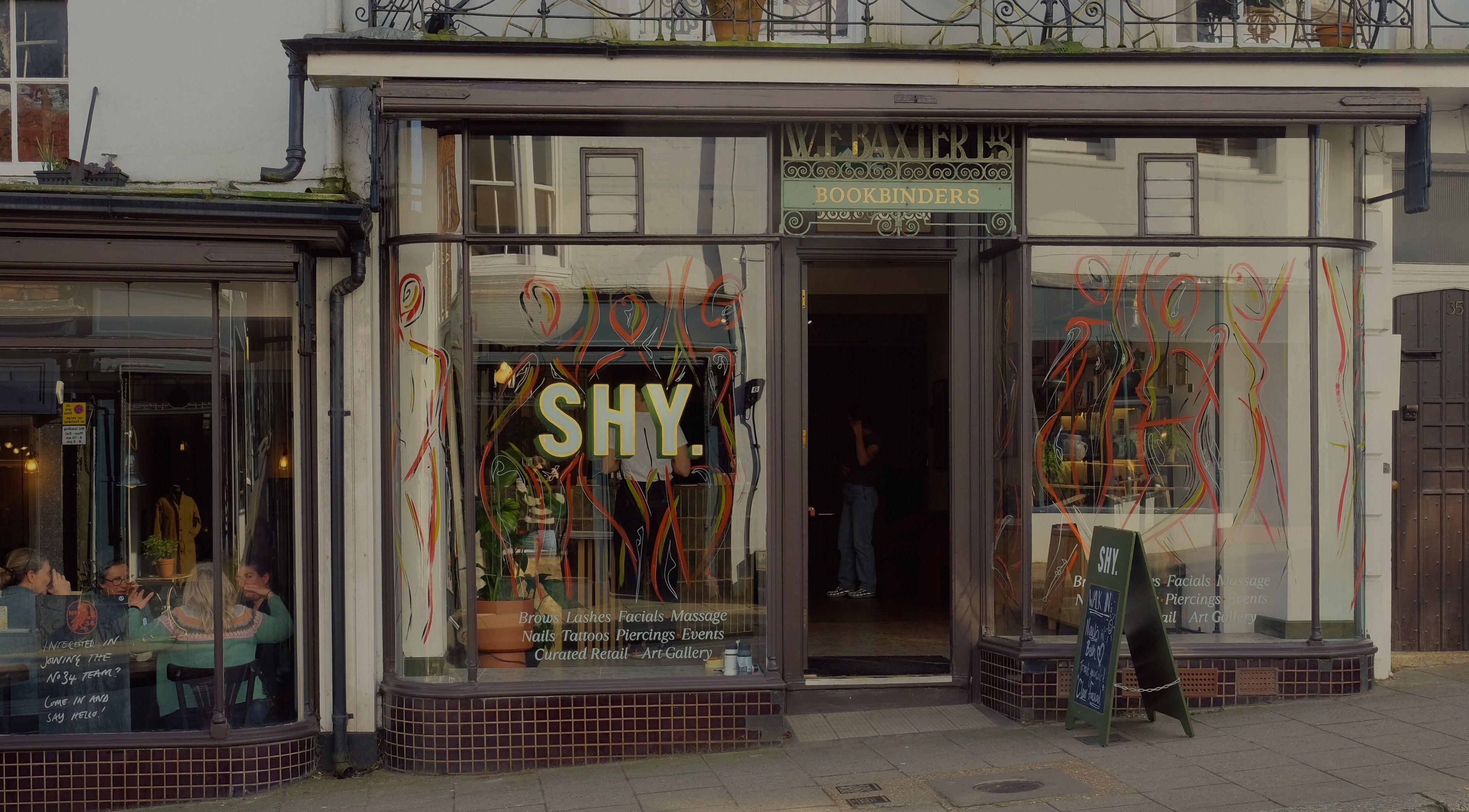 Front view of Cleo Rogers Skincare - SHY Studios in Lewes, England, showcasing vibrant window designs.