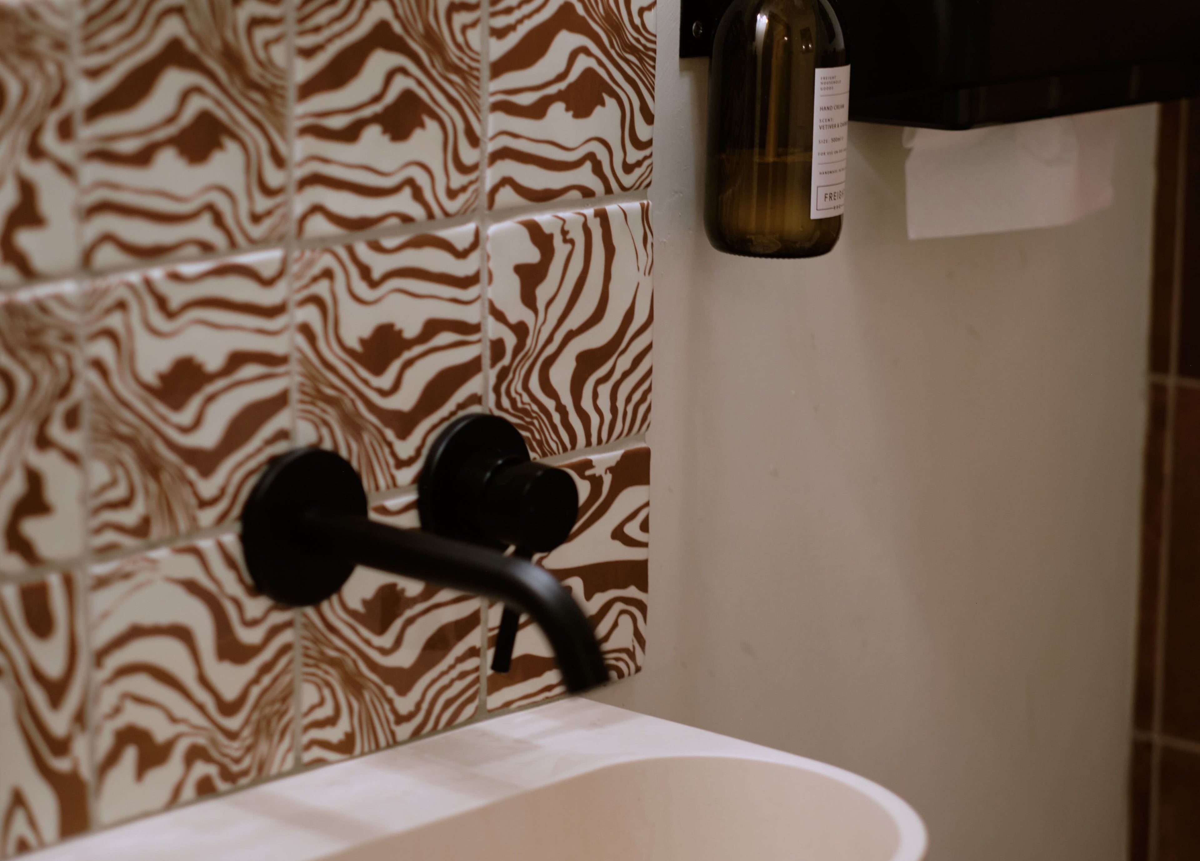 Artistic bathroom tiles and faucet at Cleo Rogers Skincare - SHY Studios in Lewes, England, GB.