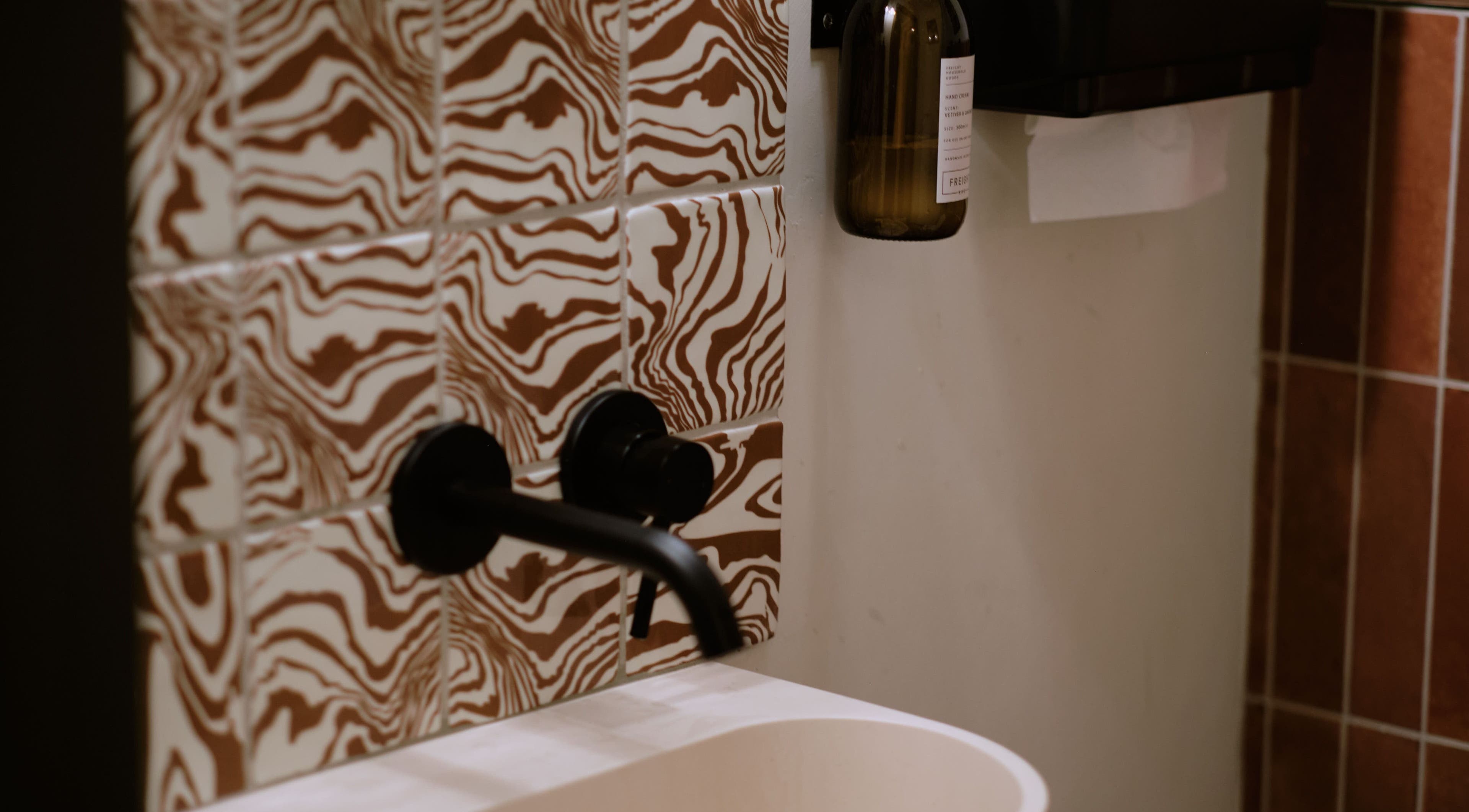 Artistic bathroom tiles and faucet at Cleo Rogers Skincare - SHY Studios in Lewes, England, GB.