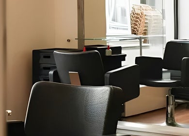 Modern black salon chair at Kukyan Hair Bar, Rīga, LV, highlighting a chic and comfortable setting.