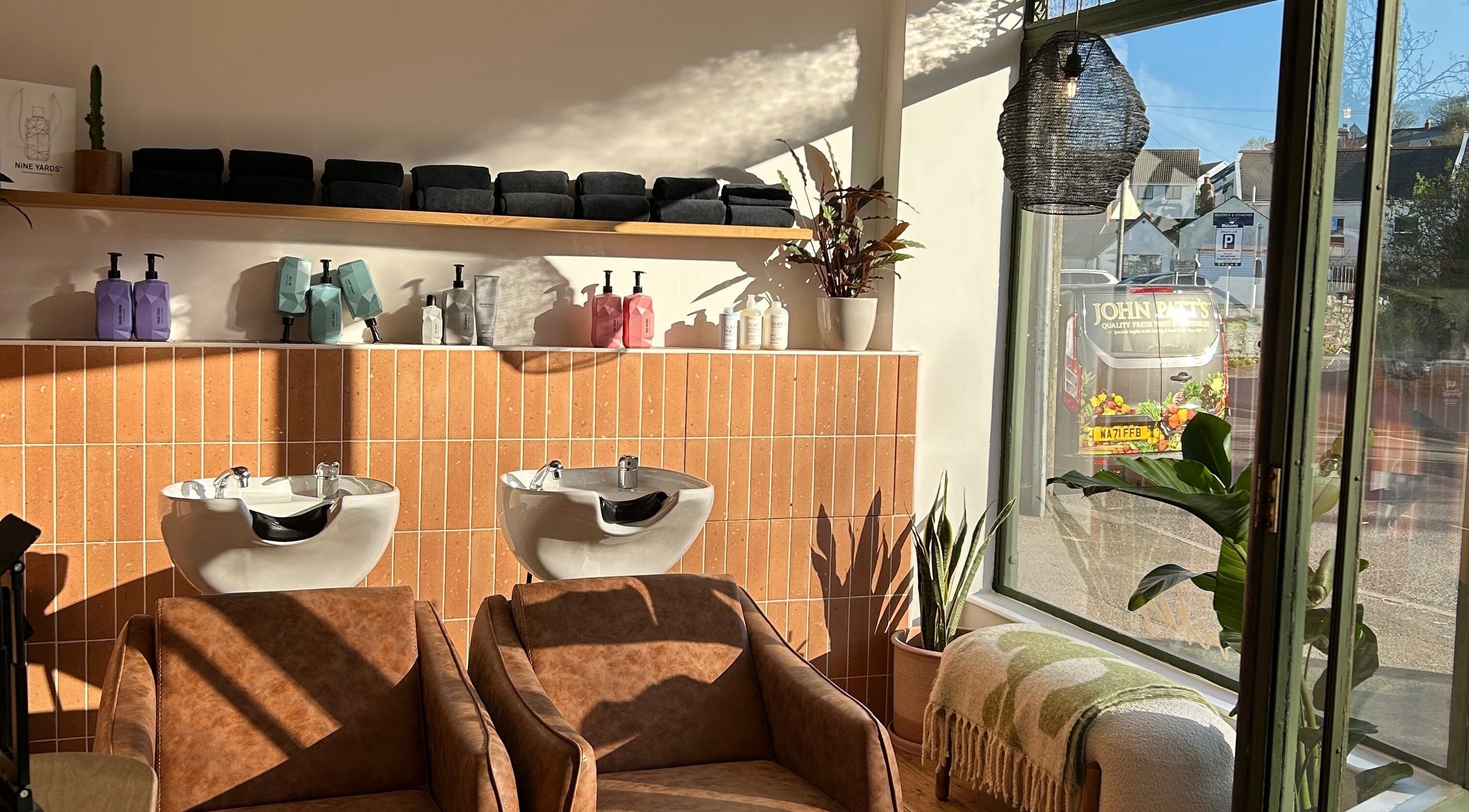 Modern wash stations at Rockey's Hair Studio, Braunton, England, GB, with elegant decor and sunlight.