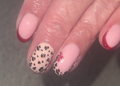 Elegant nail art at Blissful Touch Beauty By Michaela, Newry, Northern Ireland, featuring red tips and leopard design.