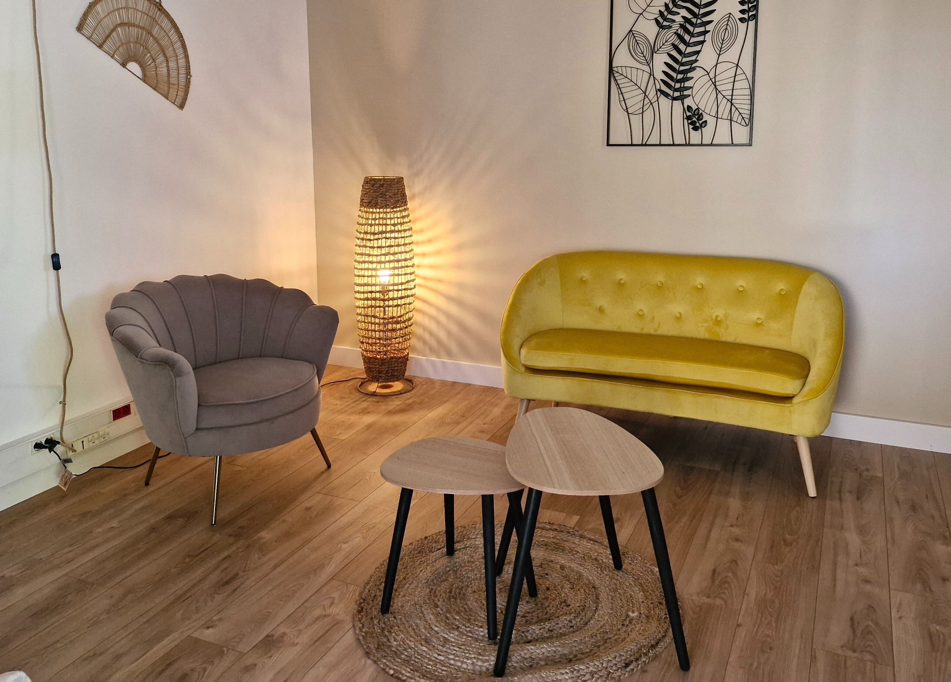 Salon élégant d'Espace Enéa à Montauban, Occitanie, FR, avec canapé jaune et fauteuil gris.