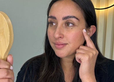 Mujer en SCSTUDIO_CL Providencia admirando su rostro en un espejo de mano.