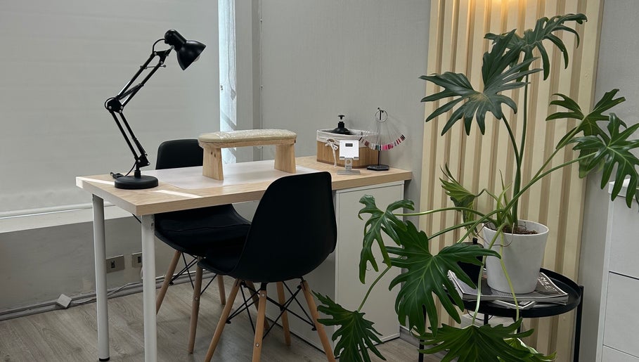 Mesa moderna en Scstudio Cl, Providencia, Región Metropolitana, CL, con planta decorativa y lámpara.