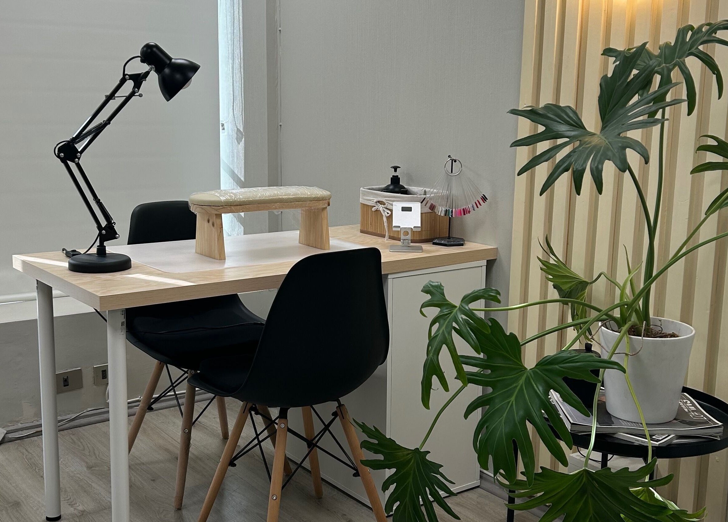 Mesa de manicura en Scstudio Cl, Providencia, Región Metropolitana, CL, con planta decorativa y lámpara moderna.