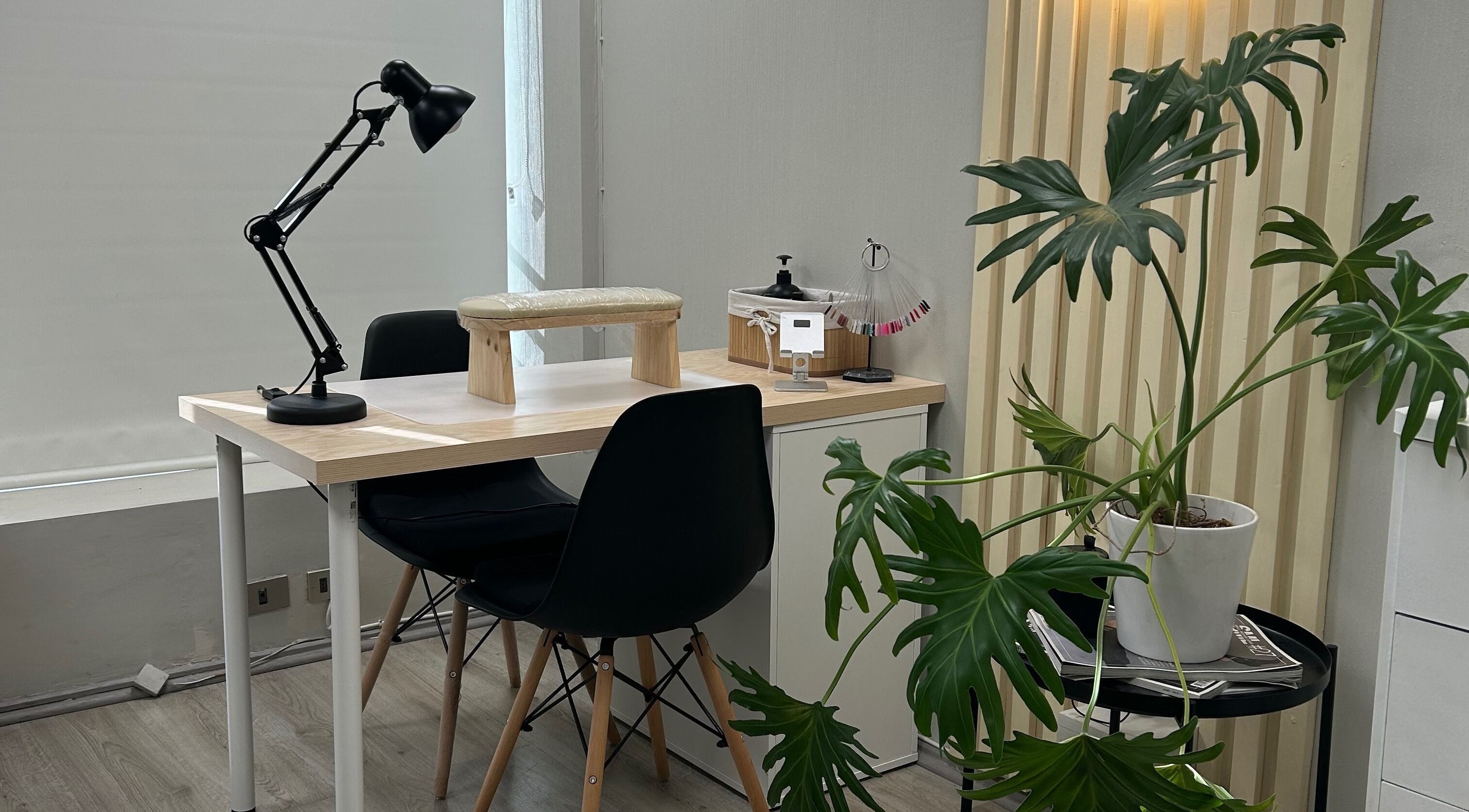 Mesa de manicura en Scstudio Cl, Providencia, Región Metropolitana, CL, con planta decorativa y lámpara moderna.