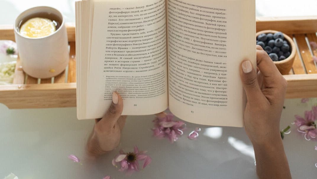 Relaxing bath with a book at Get Me Pampered (Gloucester), Gloucester, GB, featuring serene ambience and flowers.