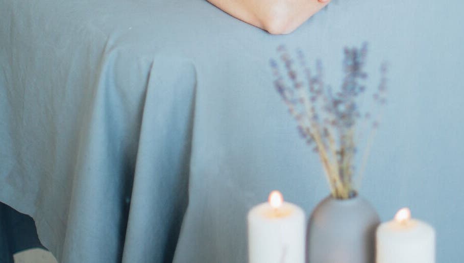Relaxing massage table with candles at Get Me Pampered, Chester, GB, creating a serene spa atmosphere.
