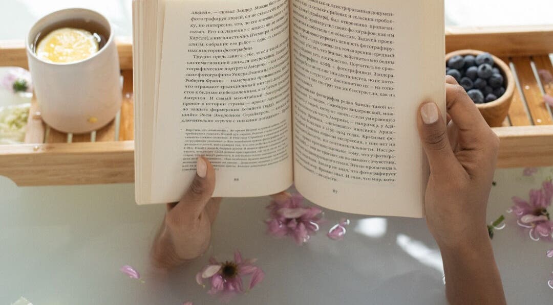 Person enjoys a relaxing bath with a book at Get Me Pampered (Salisbury), Salisbury, GB.