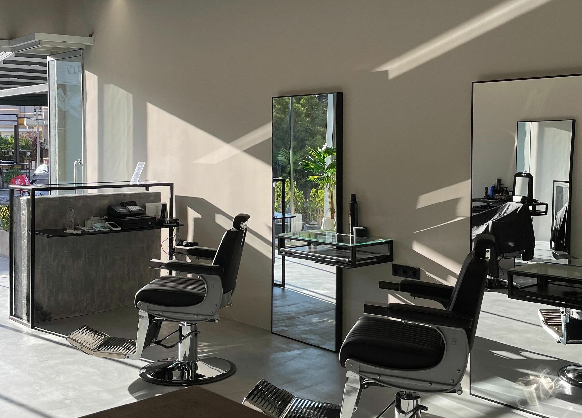 Modern salon interior at GROOMING CO. in ATHENS, GR with sleek chairs and mirrors.