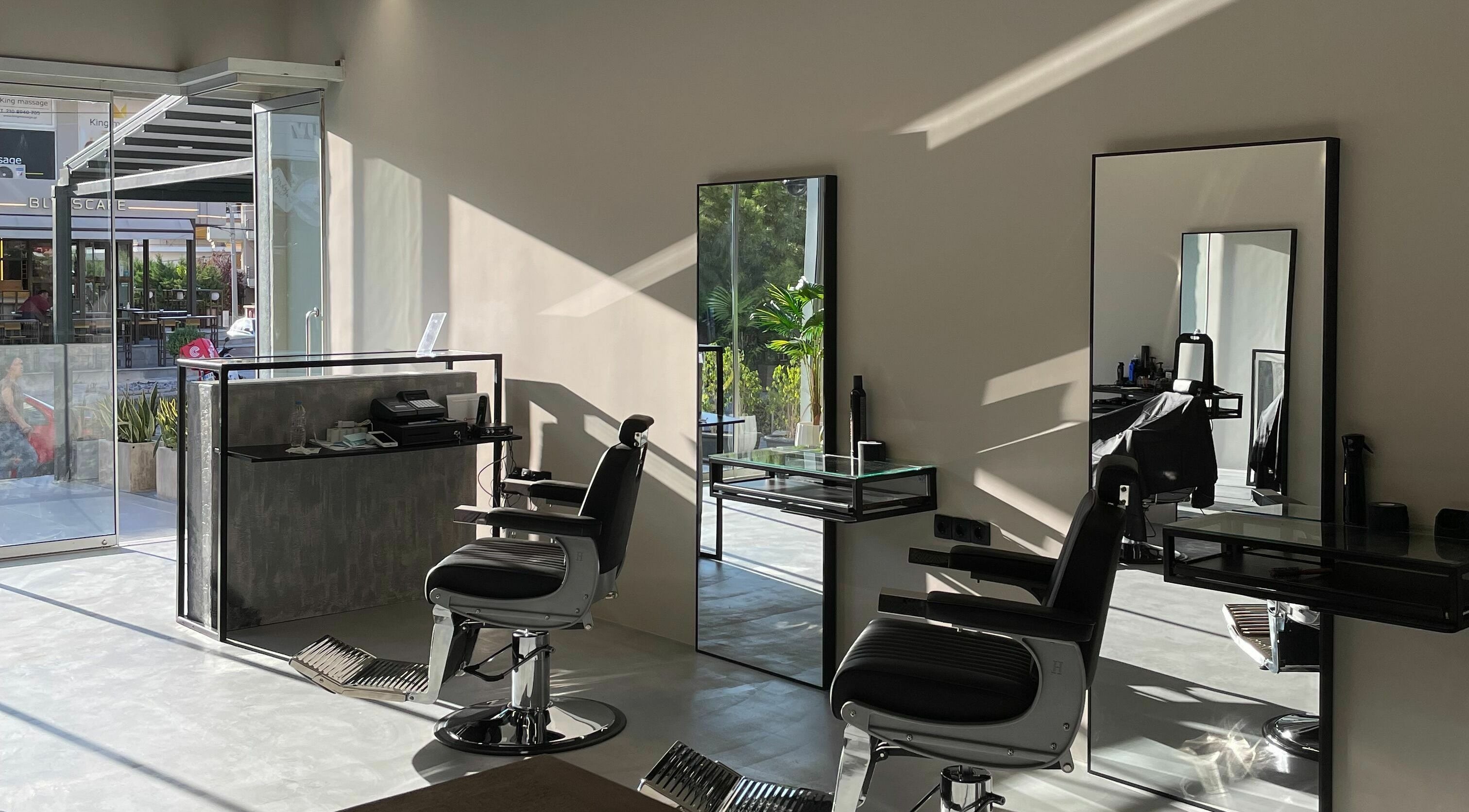 Modern salon interior at GROOMING CO. in ATHENS, GR with sleek chairs and mirrors.
