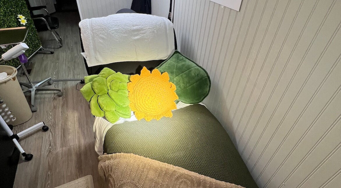 Cozy spa bed with colorful cushions at GlowLyssa Esthetics in Ada, Oklahoma, US.