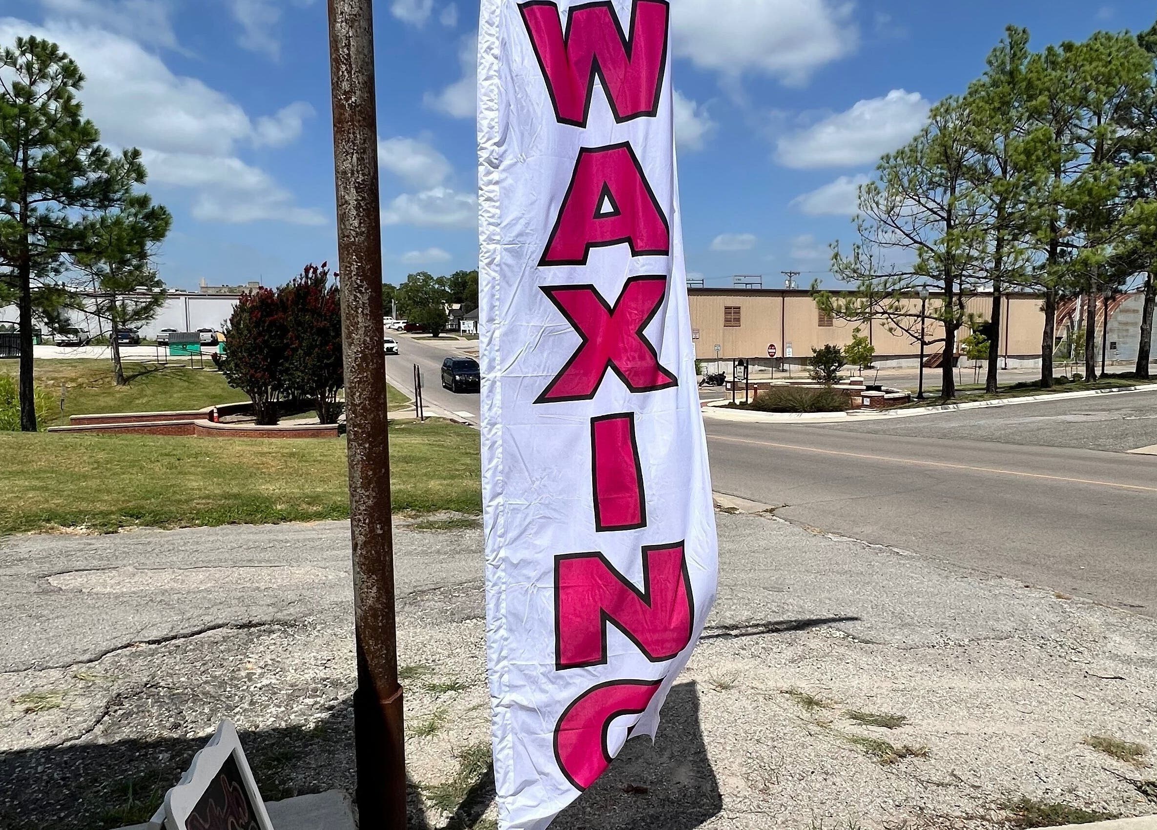 Waxing banner outside GlowLyssa Esthetics, Ada, Oklahoma, US, enhancing street view.