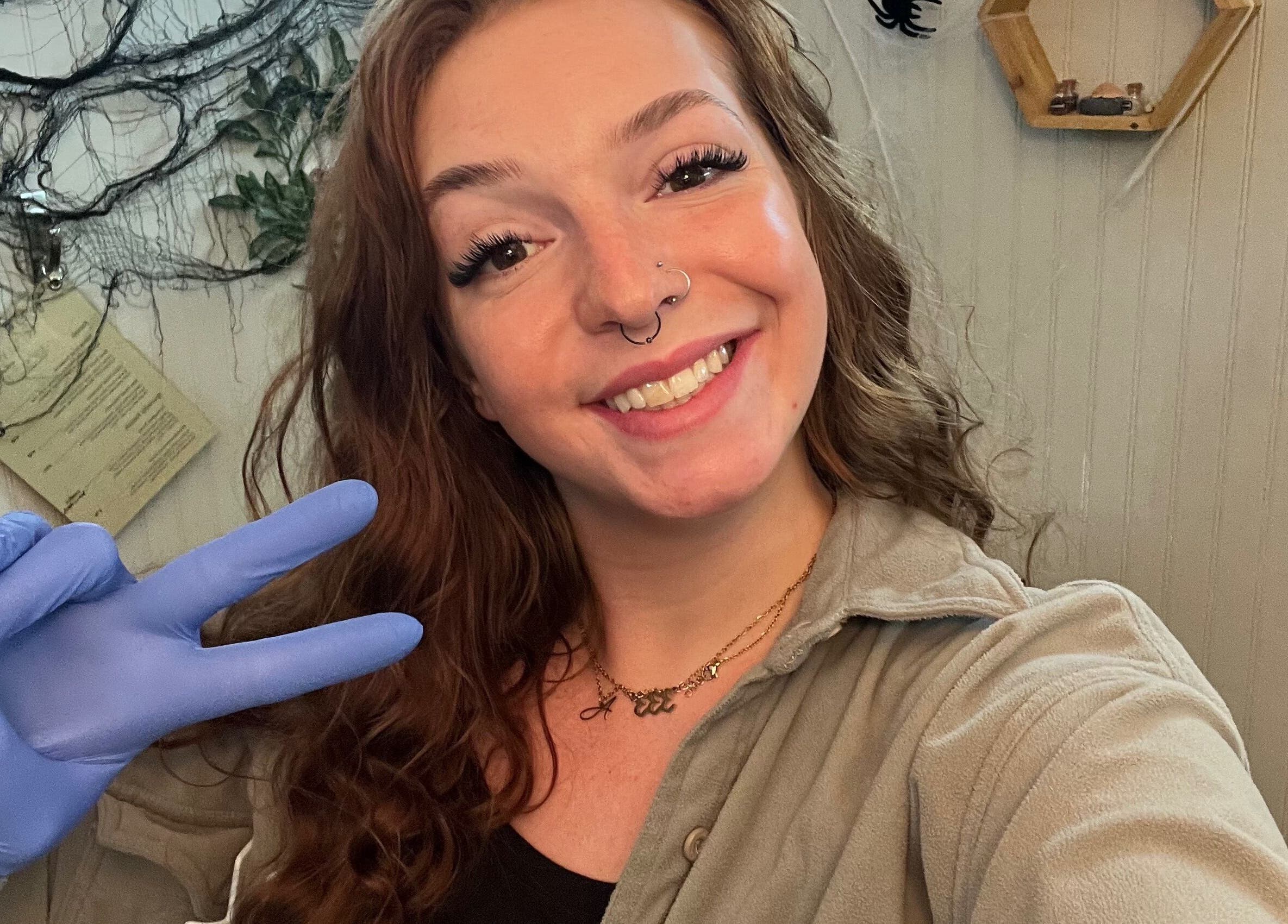 Friendly esthetician at GlowLyssa Esthetics, Ada, Oklahoma, US, wearing gloves and smiling during a beauty session.