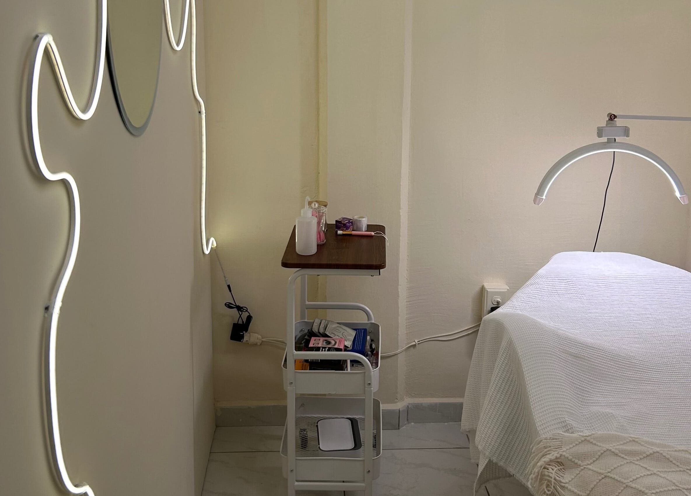 Sala de tratamiento en LEIA, Juriquilla, Querétaro, MX con iluminación moderna y camilla acogedora.