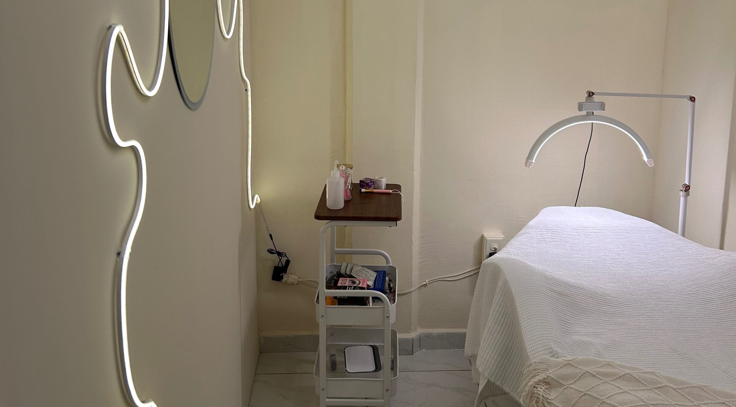 Sala de tratamiento en LEIA, Juriquilla, Querétaro, MX con iluminación moderna y camilla acogedora.