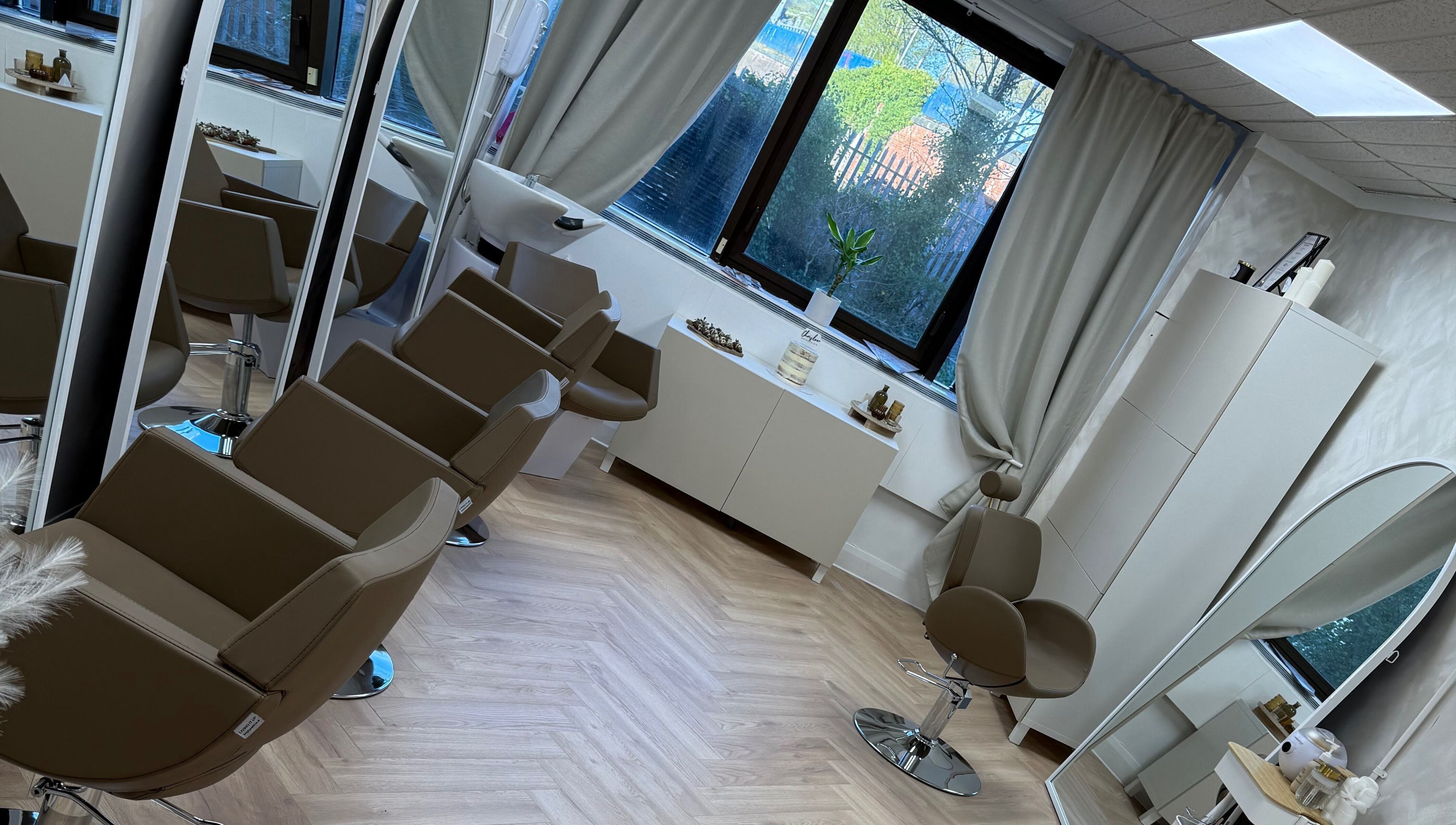 Interior of Chris Loen Hair Studio in Clydebank, Scotland, GB showcasing modern chairs and large mirrors.