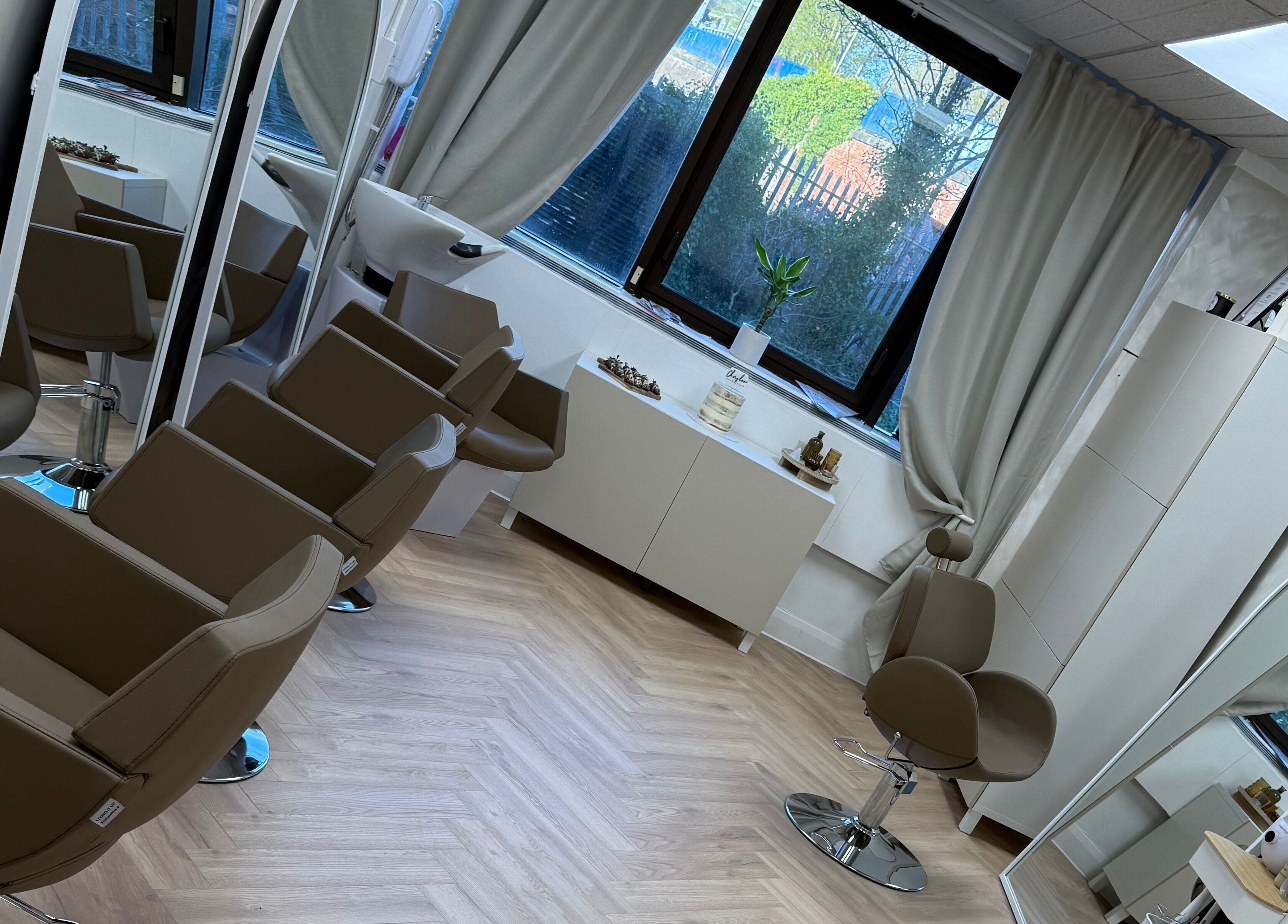 Interior of Chris Loen Hair Studio in Clydebank, Scotland, GB showcasing modern chairs and large mirrors.