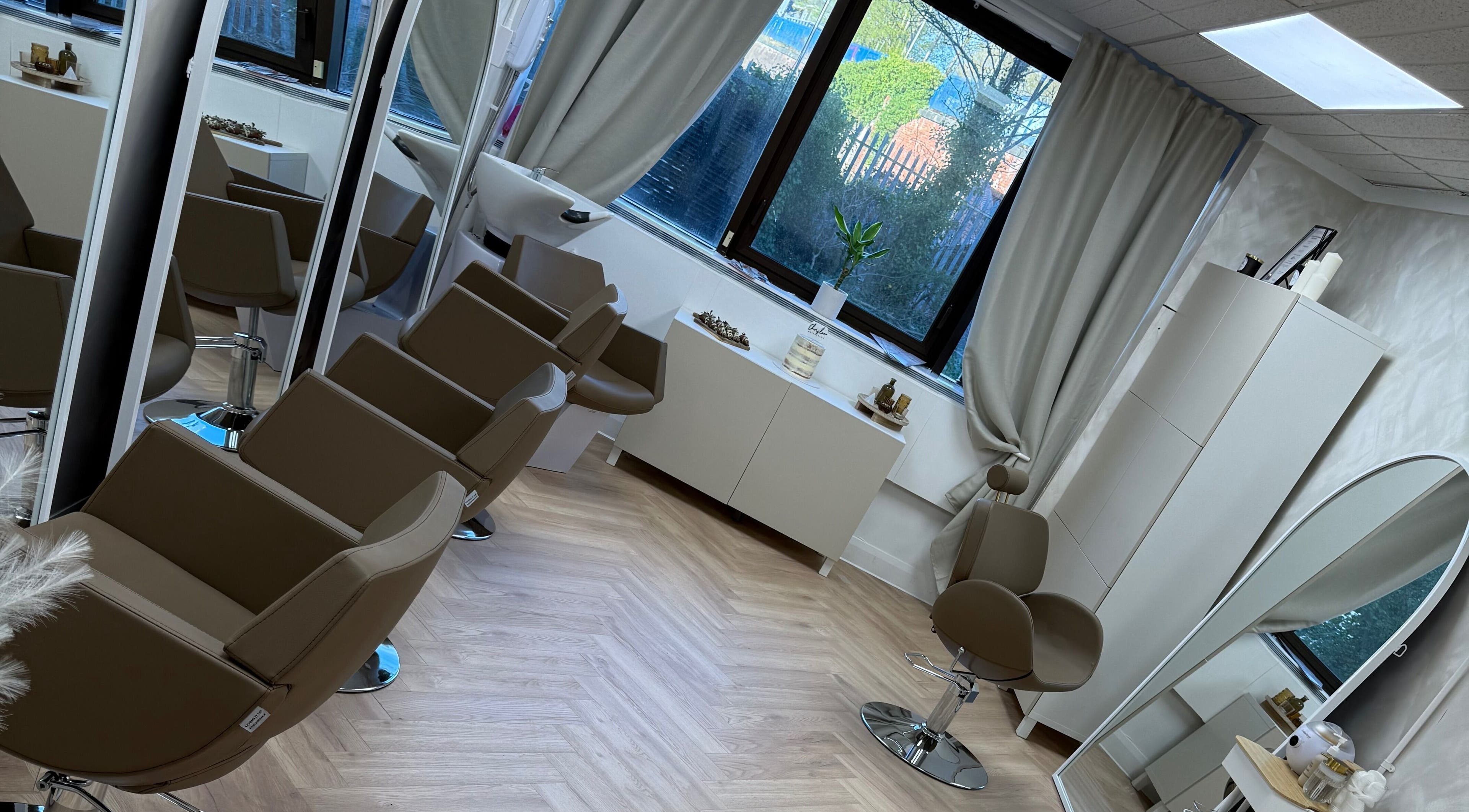 Interior of Chris Loen Hair Studio in Clydebank, Scotland, GB showcasing modern chairs and large mirrors.