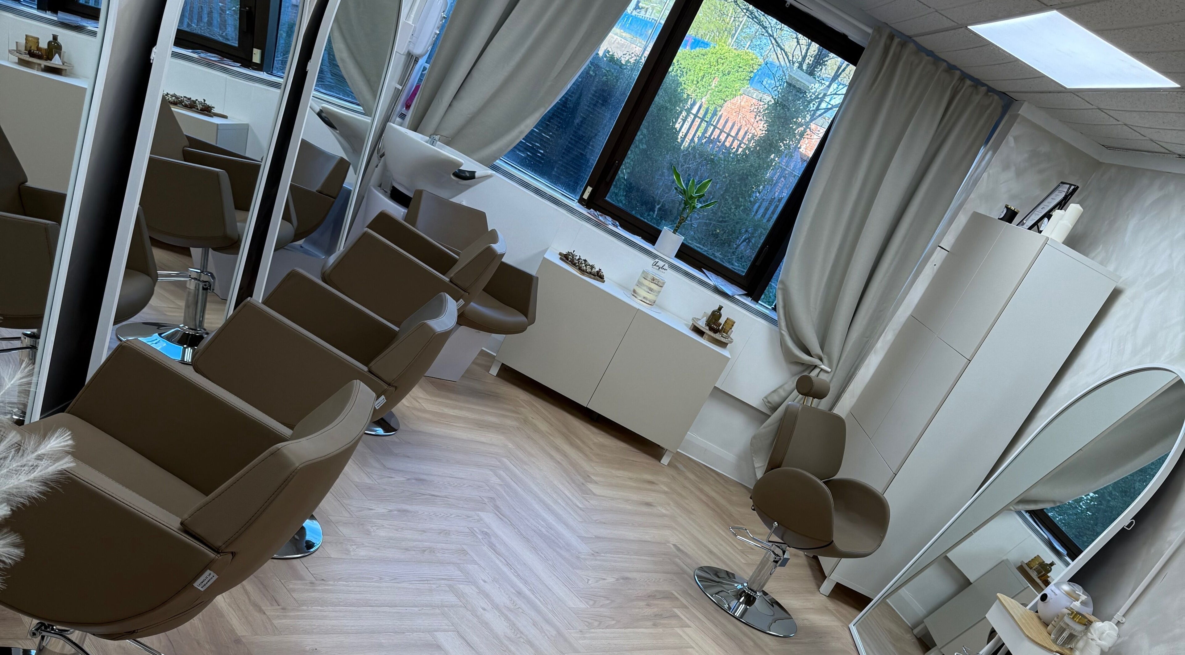 Interior of Chris Loen Hair Studio in Clydebank, Scotland, GB showcasing modern chairs and large mirrors.