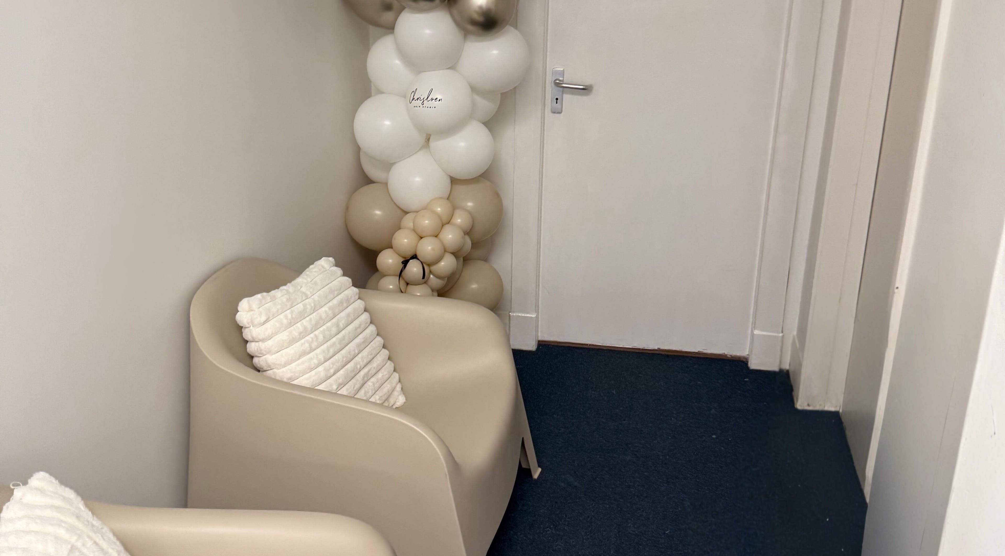 Inviting seating area at Chris Loen Hair Studio, Clydebank, Scotland, GB, featuring elegant decor and plush pillows.