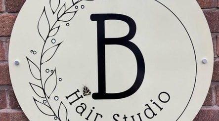 Stylish hair studio sign at Anastasia, Taunton, England, GB, with decorative leaf design.
